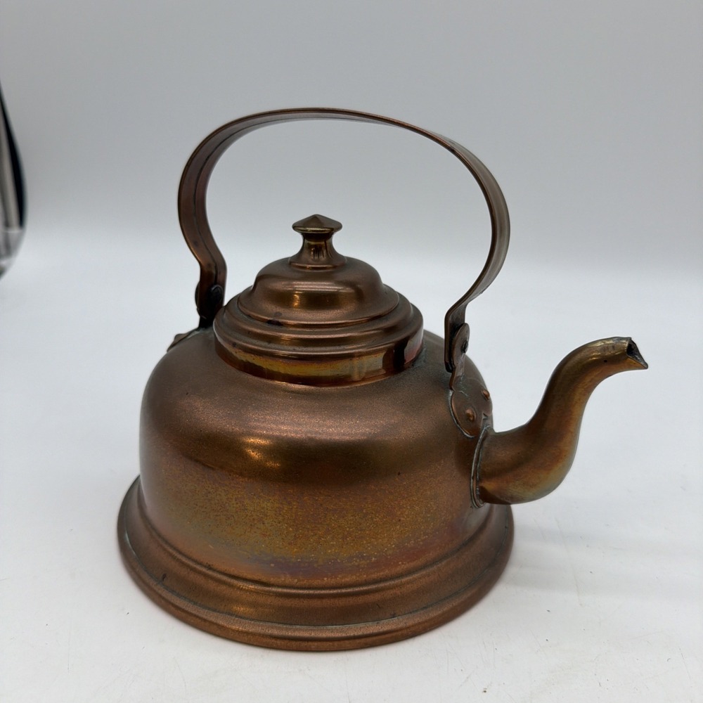 antique copper tea kettle featuring an arched handle